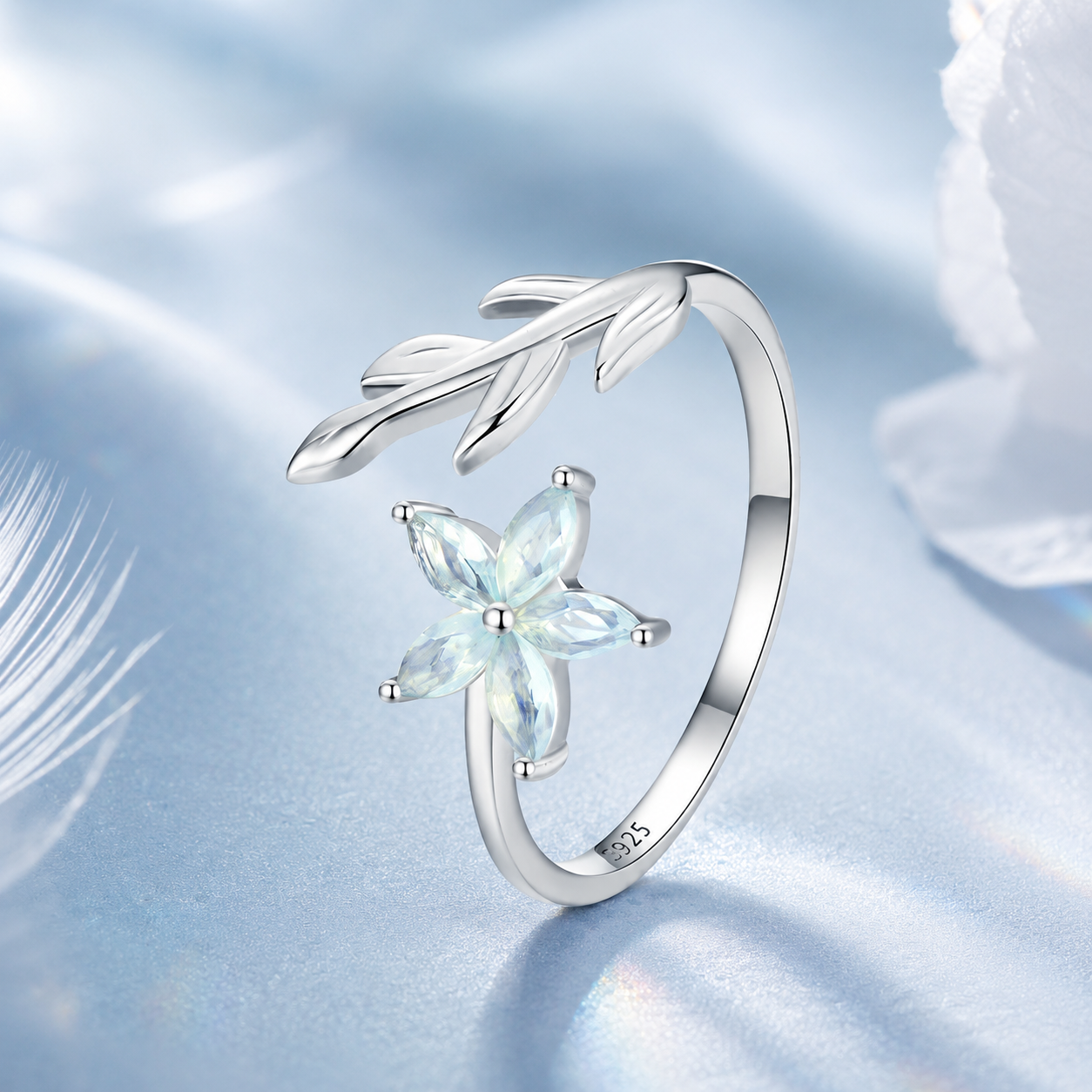 Silver ring with a star-shaped gemstone on a soft blue background