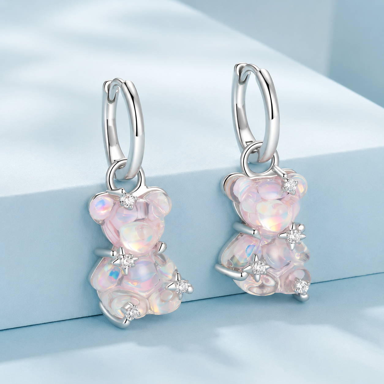 Silver earrings with pink gemstones on a light blue background