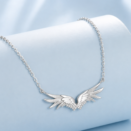 Silver wing-shaped necklace on a light blue background