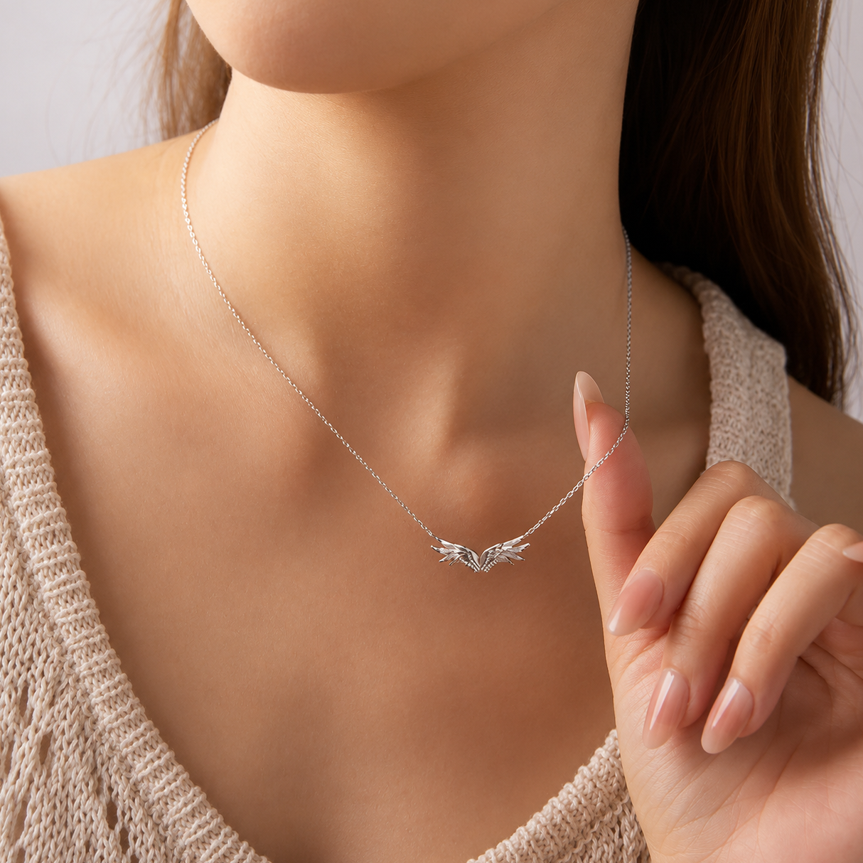 Silver necklace with a delicate pendant worn by a person