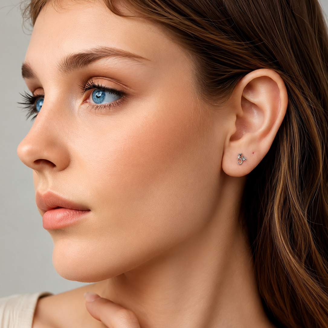 Close-up of a woman wearing a diamond earring against a neutral background