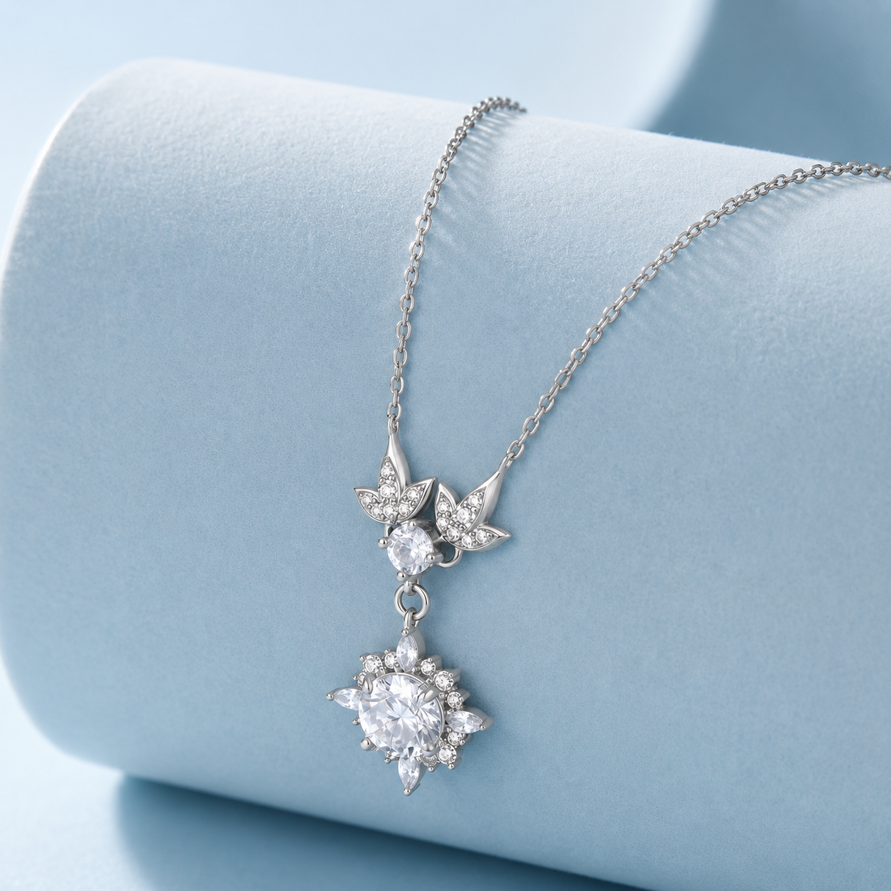 Silver necklace with star-shaped pendants on a light blue background
