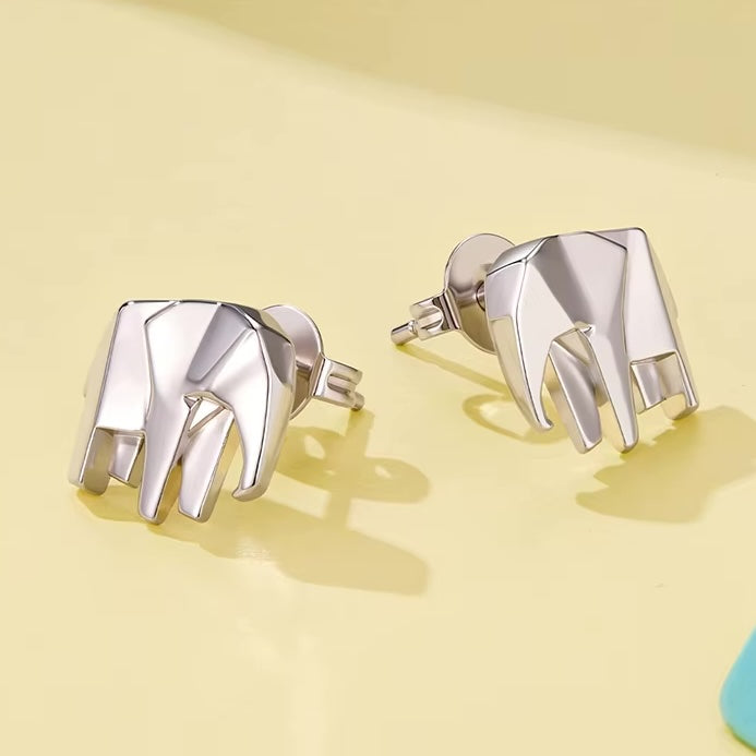 Silver elephant-shaped earrings on a yellow background