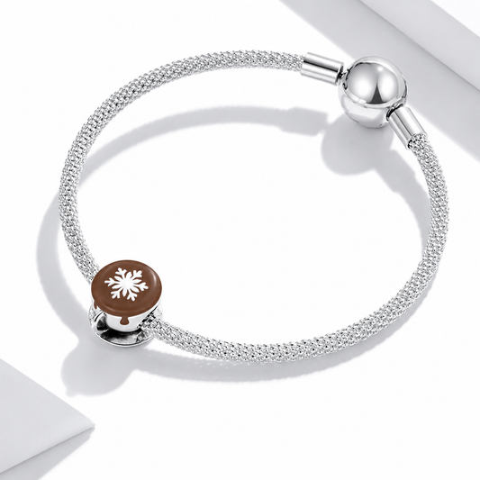 Silver bracelet with a brown charm featuring a snowflake design on a white background