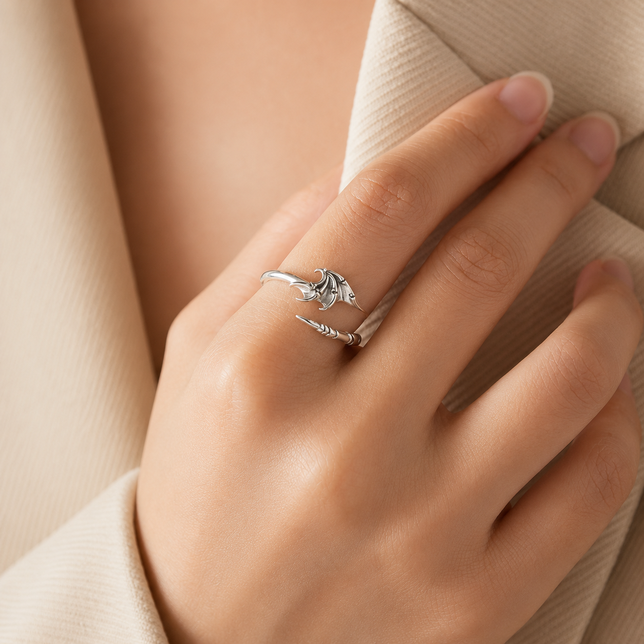 Silver ring on a person's finger with a soft beige background