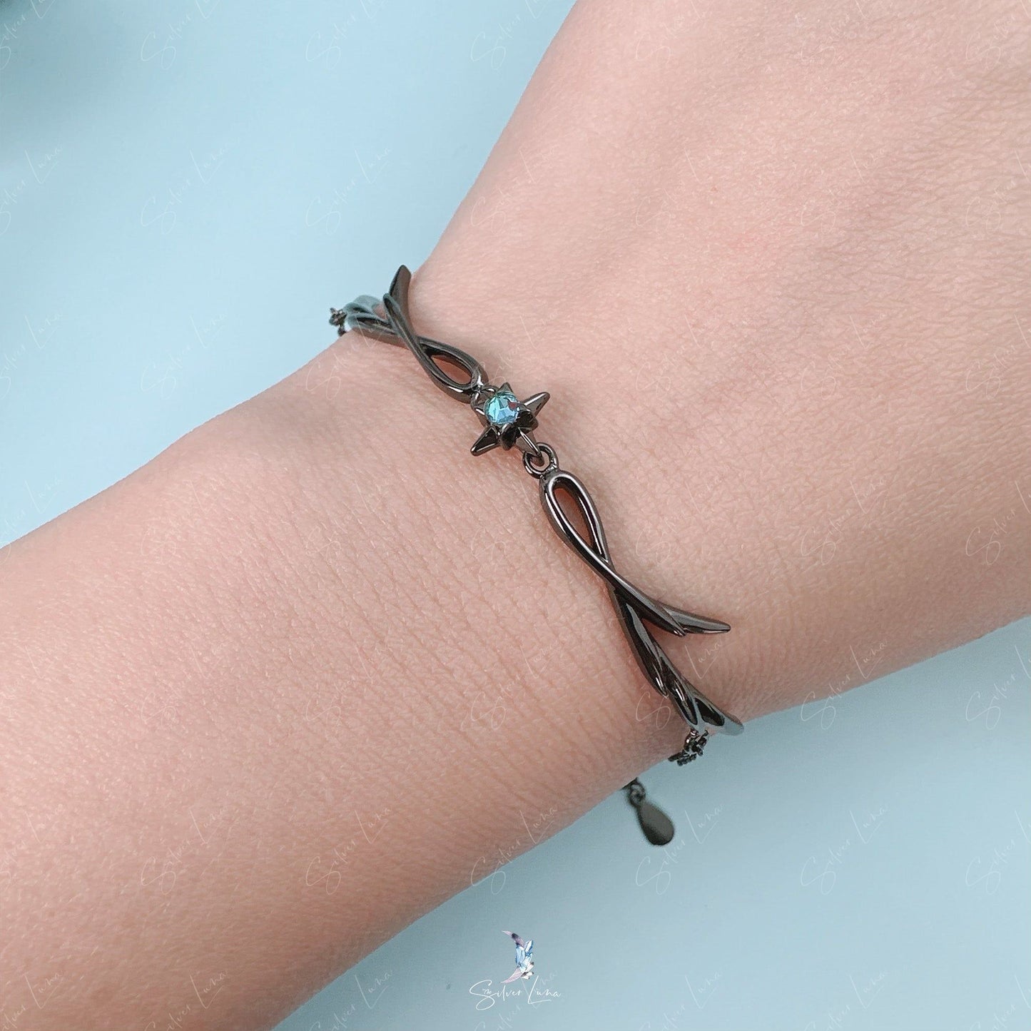 Black tree branch with blue star bracelet