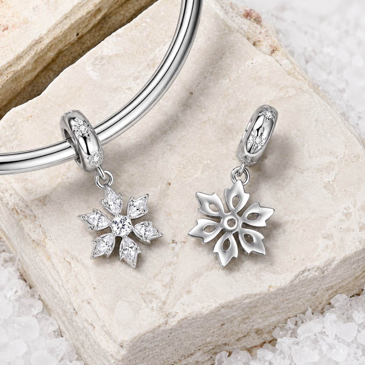 Silver bracelet with snowflake charms on a textured stone surface